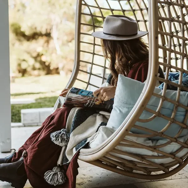 relaxing in a hangin egg chair at bethany beach house backyard